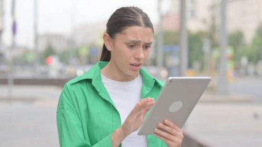 Upset Young Woman Reacting to Loss on Tablet Outdoor