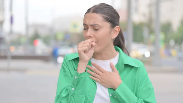 Young Woman Coughing while Standing Outdoor