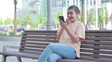 Akıllı telefonda kutlama yapan başarılı genç Hintli kadın.