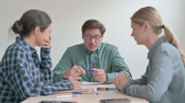 Kızgın Orta yaşlı adam İşçilerle konuşuyor.