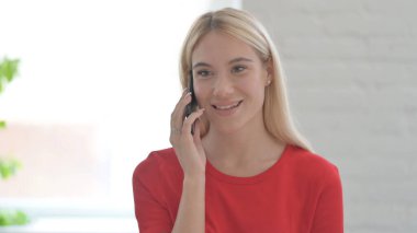 Genç kadın telefonda konuşuyor, iş konuşuyor.