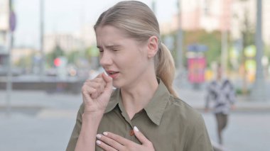 Unwell Young Woman Coughing while Standing Outdoor