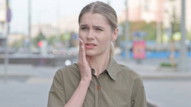 Discomforted Young Woman with Toothache Standing Outdoor