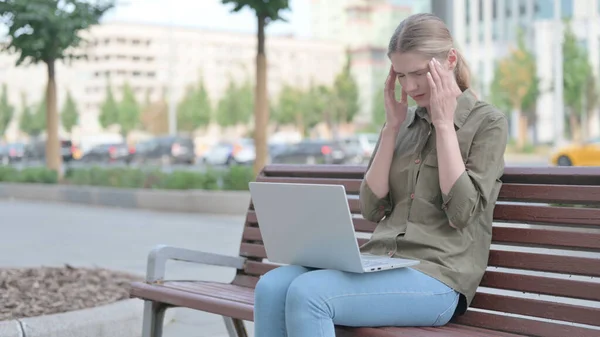 Молода Жінка Головним Болем Допомогою Ноутбука Сидячи Відкритому Повітрі Лавці — стокове фото