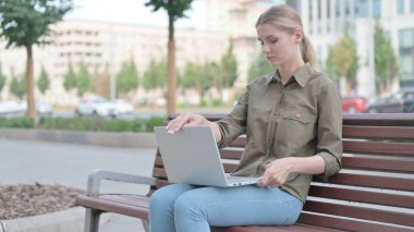 Genç Kadın Laptop Kapanış sonra Bench Bırakarak