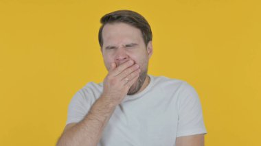 Tired Casual Young Man Yawning on Yellow Background 