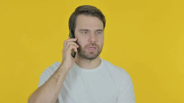 Случайный Молодой Человек Разговаривает Телефону Желтом Фоне — стоковое фото