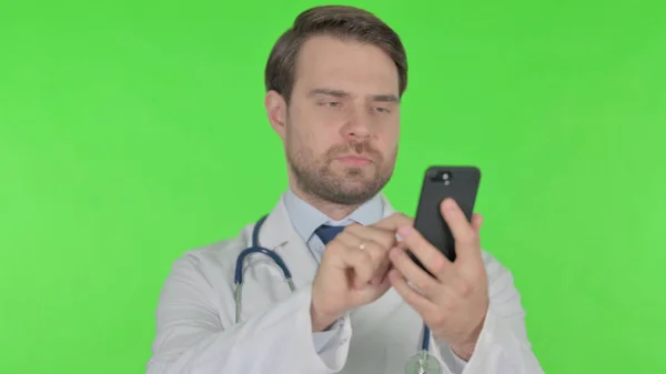 Young Adult Doctor Browsing Smartphone Green Background — Fotografia de Stock