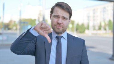 Thumbs Down By Middle Aged Businessman Standing Outdoor