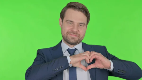 Young Adult Businessman Showing Heart Shape Hands Green Background — стоковое фото