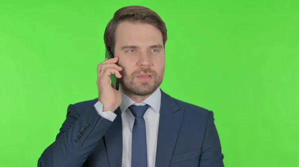 Молодий Дорослий Бізнесмен Говорить Телефону Зеленому Тлі — стокове фото