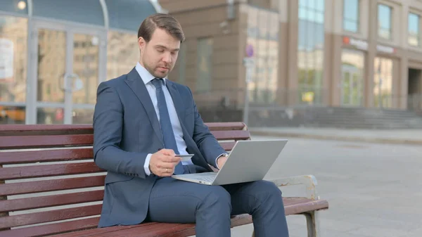 Excited Young Businessman Shopping Online Sitting Outdoor — ストック写真
