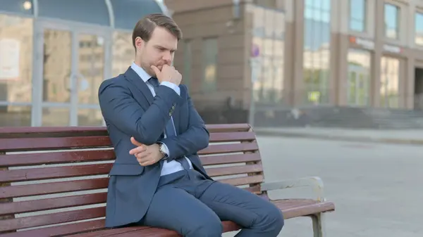 Pensive Young Businessman Thinking While Sitting Outdoor Bench — ストック写真