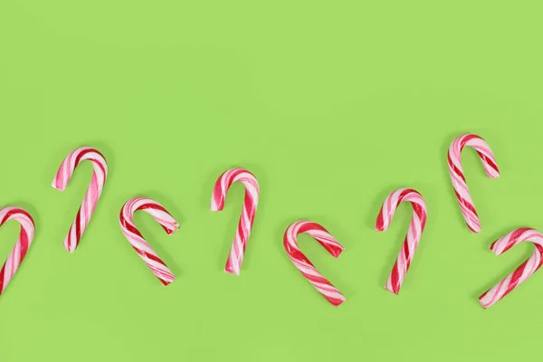 小さな赤と白の縞模様緑の背景に行のクリスマスのお菓子 — ストック写真