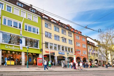 Freiburg, Almanya - Nisan 2022: Mağazalar ve güneşli bahar gününde yürüyen insanlarla dolu şehir merkezi