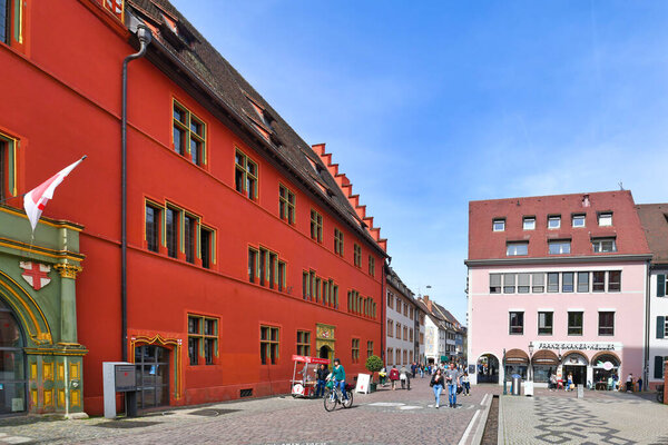 Freiburg, Germany - April 2022: Bright red building of tourist information at Rathausplatz town square
