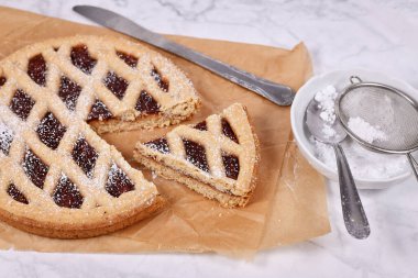 'Linzer Torte' adında bir dilim turta, üzerinde meyve reçelleri ve kafes tasarımlı fındıklı geleneksel Avusturya pastası.