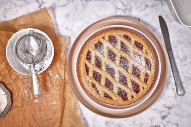 Top view of pie called 'Linzer Torte', a traditional Austrian shortcake pastry topped with fruit preserves and nuts with lattice design