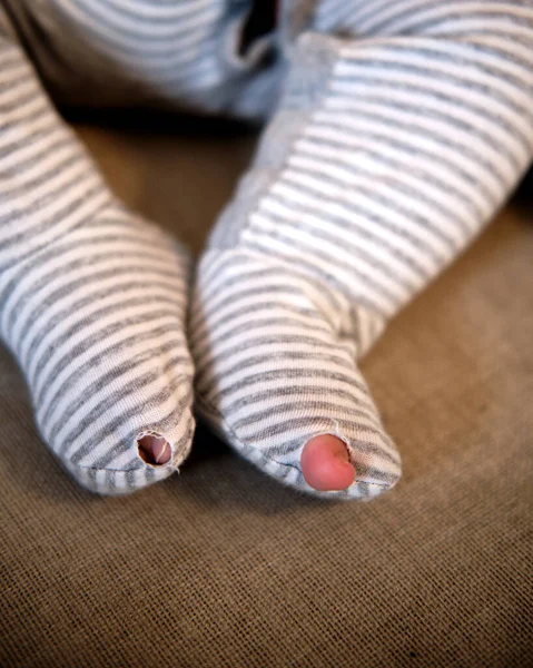 Roupas de bebê com um buraco no pé — Fotografia de Stock