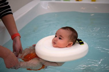 Bebek jakuzide annesiyle eğleniyor. Bebekler için spa. Çocuklar için hidroterapi seansı. Bebek yüzme
