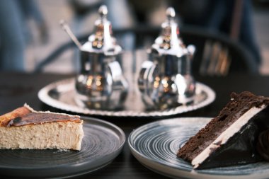 Arap çay dükkanının terasında iki tatlıya çay eşlik ediyormuş. Çikolatalı kek ve peynirli kek.