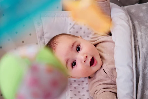 Младенец играет с музыкальной кроваткой — стоковое фото