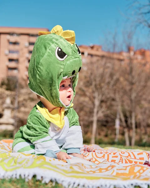 Dinozor kostümü giymiş bir bebek.