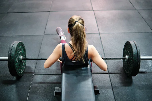 Spor salonunda spor yapan genç bir kadın.