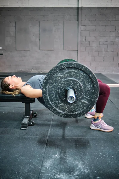 Spor salonunda spor yapan genç bir kadın.