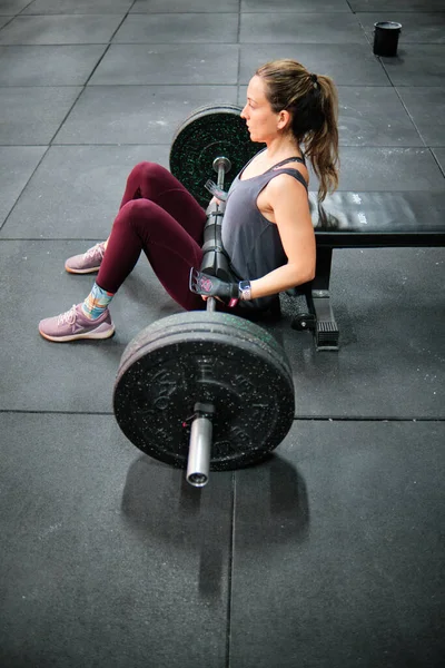 Spor salonunda spor yapan genç bir kadın.
