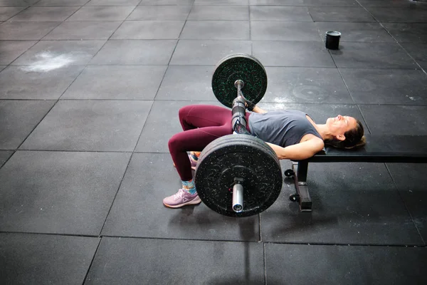 Spor salonunda spor yapan genç bir kadın.