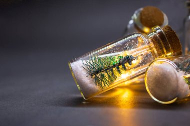 İçinde ladin ve kar olan bir ampul. Akşamları, karanlık arka planda mesaj için yer var. Noel atmosferi, yeni yıl, tatil, kış. Boşluğu kopyala