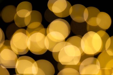 Odaklanamayan ışıklar, siyah arka planda sarı bokeh, üst üste. Noel, Yeni Yıl