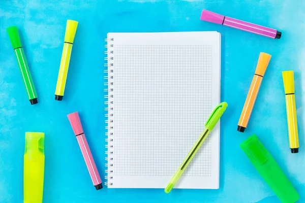 青い水彩を背景にペンと多色のマーカーとフェルトのペンでチェックしたノート 学校のコンセプトに戻る 描画します スペースのコピー — ストック写真