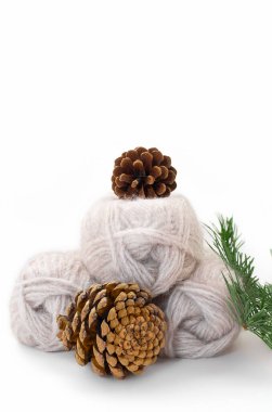 Beyaz arka planda külahlı gri yün iplikler ve ladin dalları. Örgü, dikiş işi. Boşluğu kopyala