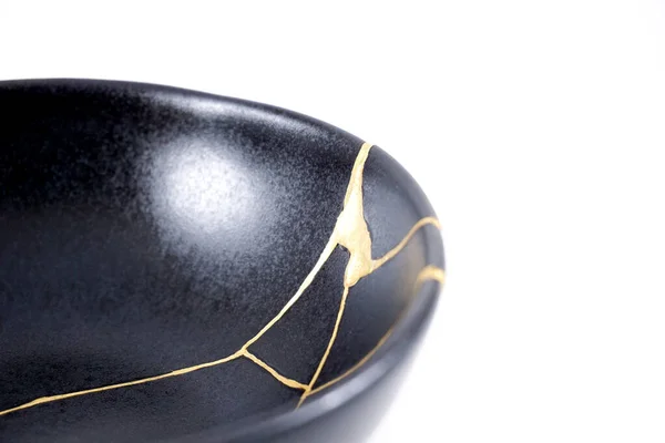 Isolated Black Japanese Kintsugi Bowl Antique Pottery Restored Gold Cracks Stockfoto