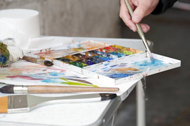 Boya malzemesi kullanan bir ressam (yağlı boya, sanatçı fırçası))