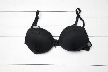Beyaz masada siyah kadın sütyeni. Kopya alanı olan kadın iç çamaşırı arka planı
