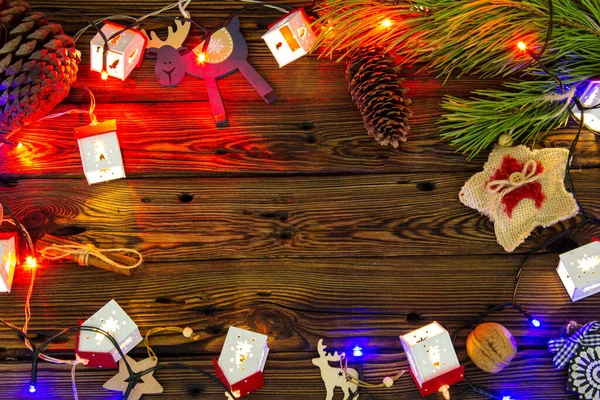 圣诞树玩具和松枝间木制背景上的糖果 — 图库照片