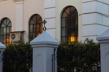 Sabah güneşinde çitin arkasındaki Katolik kilisesinin pencereleri..