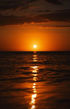 Denizden gün doğumu, suyun üzerindeki güneş, turuncu ışık.