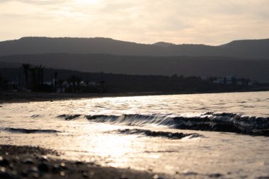 Dalgalar deniz kenarında, berrak mavi su