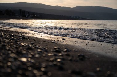 Dalgalar deniz kenarında, berrak mavi su