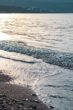 Dalgalar deniz kenarında, berrak mavi su