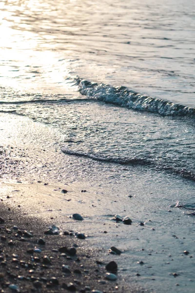 Dalgalar deniz kenarında, berrak mavi su