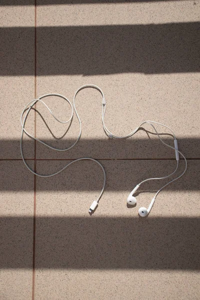 White earphones in the sun-light, left and right, apple earphones
