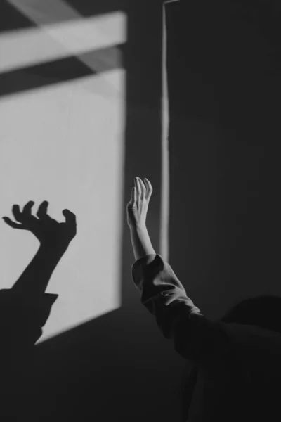 Female hand on the wall, shadow black and white, changed form geometry