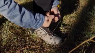 Close-up detail of a mountaineer tying his shoe during a route.