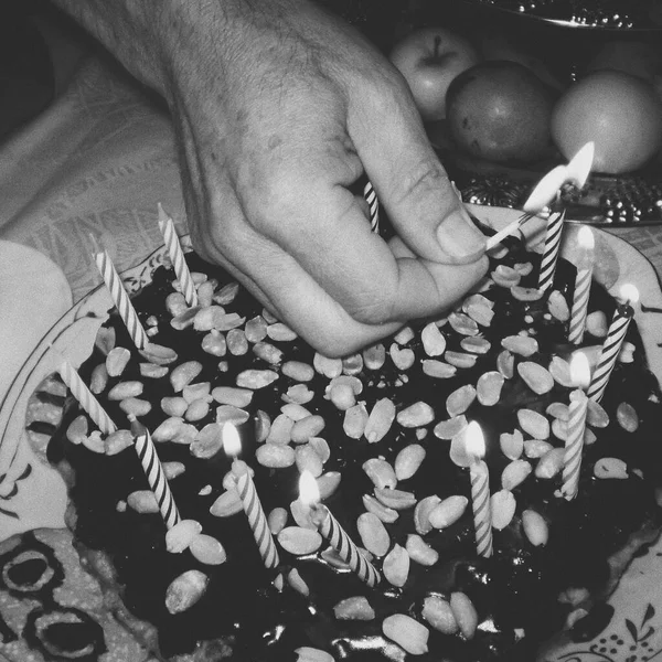 Adam doğum günü pastasında mum yakıyor. Tatlı çikolatalı tatlı. siyah ve beyaz bağbozumu tarzı