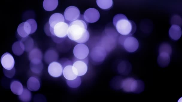 Defokussierte violette Bokeh-Kugeln flackern in der Nacht. abstrakte verschwommene Weihnachtsbeleuchtung Hintergrund — Stockvideo